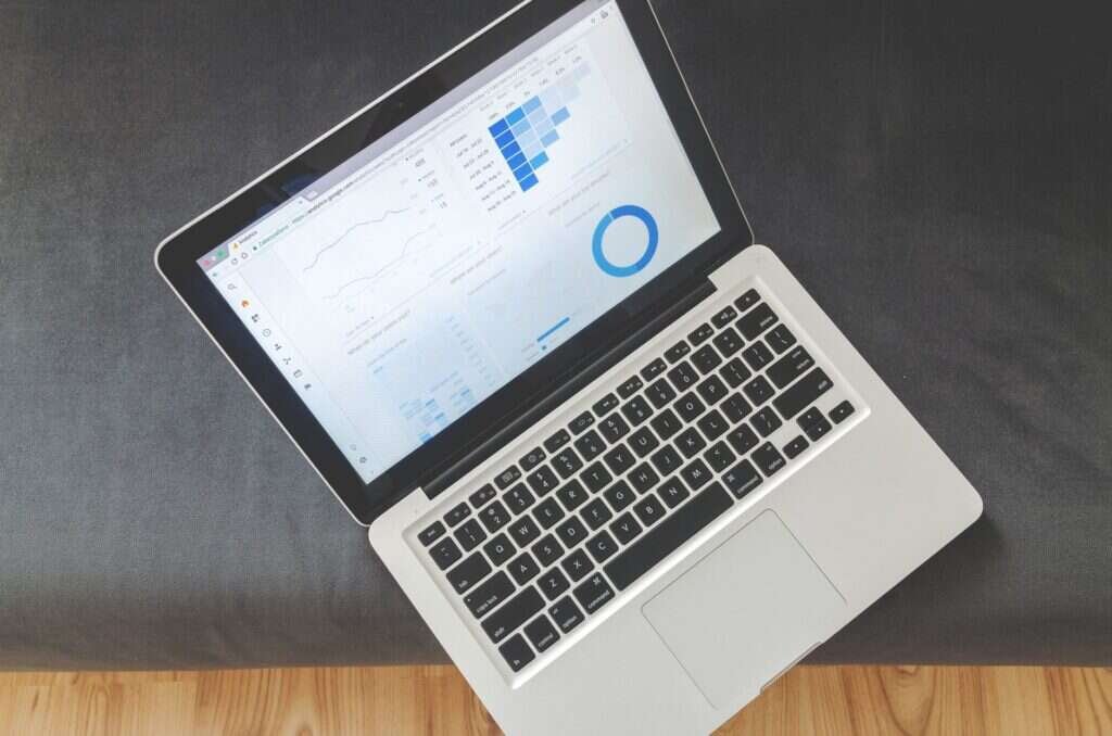 Vista cenital de un portátil con gráficos de datos sobre una mesa de trabajo